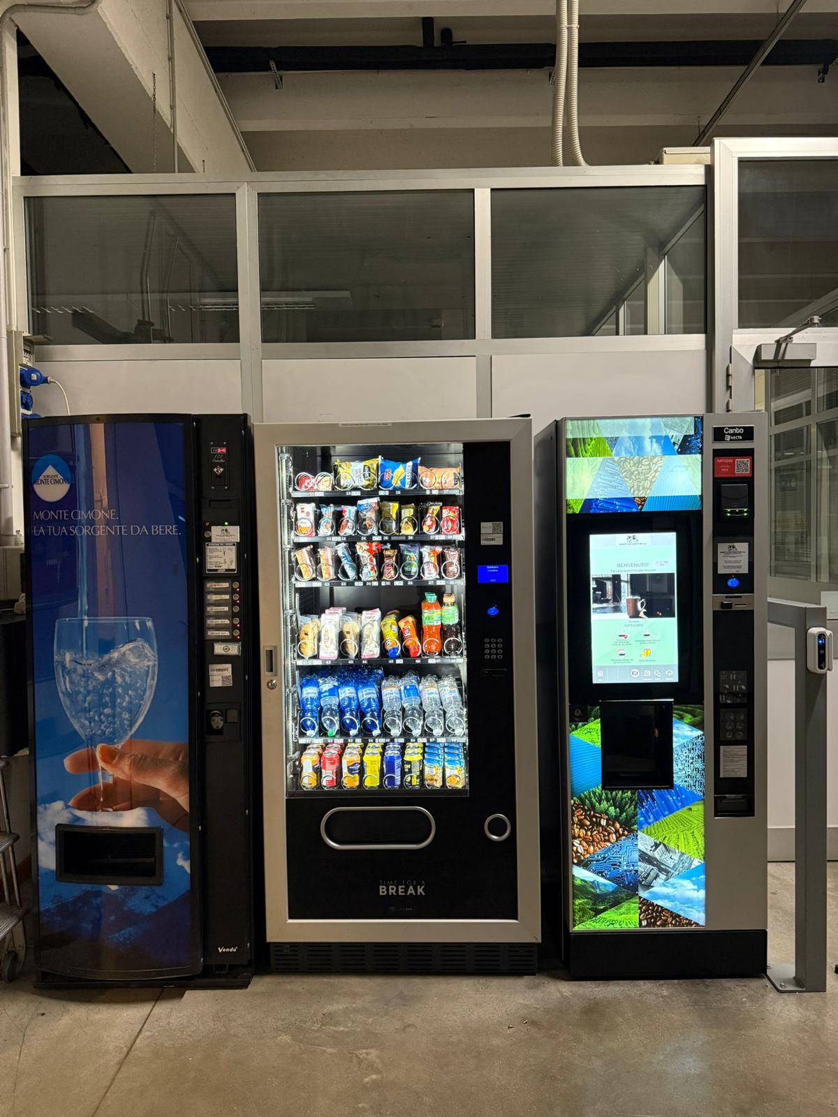 Area break completa con distributori di acqua, snack e caffè in un'industria